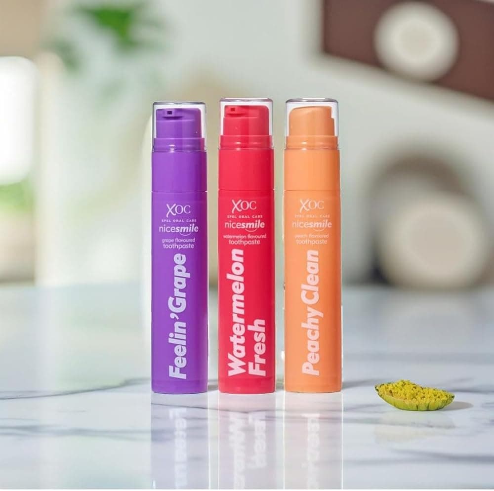 Nice Smile Feelin' Grape, Watermelon Fresh and Peachy Clean toothpaste tubes on a marble bathroom counter